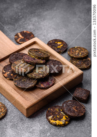 Organic Chinese green pu-erh tea with various herbs in round bricks. Chinese pu-erh tea Organic Chinese green pu-erh tea with various herbs in round bricks. Chinese pu-erh tea 138370096