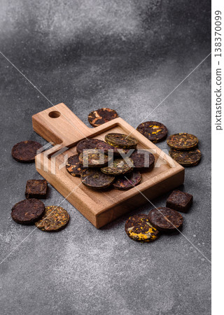 Organic Chinese green pu-erh tea with various herbs in round bricks. Chinese pu-erh tea Organic Chinese green pu-erh tea with various herbs in round bricks. Chinese pu-erh tea 138370099