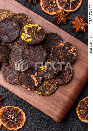 Organic Chinese green pu-erh tea with various herbs in round bricks. Chinese pu-erh tea Organic Chinese green pu-erh tea with various herbs in round bricks. Chinese pu-erh tea 138370106