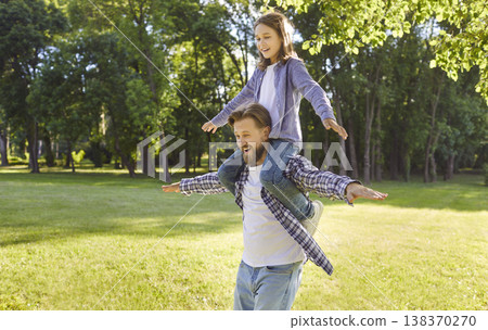 Happy child boy sitting on fathers shoulders having fun together enjoying nature in summer park. Happy child boy sitting on fathers shoulders having fun together enjoying nature in summer park. 138370270