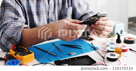 Service Technician Inspects Old Smartphone With Broken Screen Service Technician Inspects Old Smartphone With Broken Screen 138370310