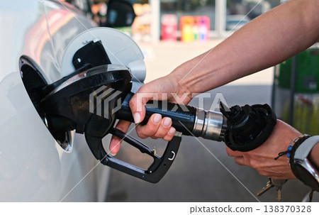 Girl Refueling Her Car, Holding Fuel Nozzle On A Petrol Station 138370328