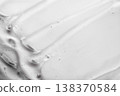 Gel substance spreading across white surface, creating cosmetic texture 138370584