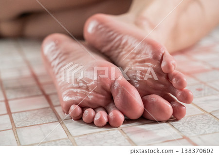 Foot fetish. A woman pours wine on her feet. Foot fetish. A woman pours wine on her feet. 138370602