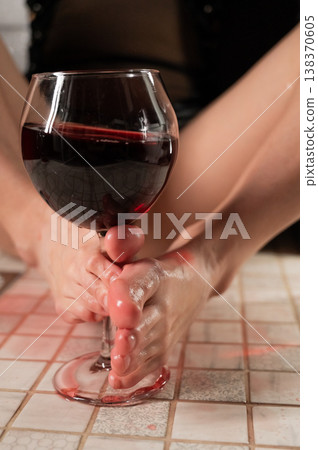 Foot fetish. A woman pours wine from a glass onto her feet in the shower. Foot fetish. A woman pours wine from a glass onto her feet in the shower. 138370605