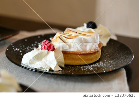 French tarte au citron with meringue and berries dessert plate French tarte au citron with meringue and berries dessert plate 138370625