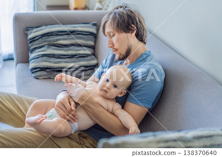 Tired father falling asleep on couch while holding baby at home. Exhausted dad struggling with lack of sleep and childcare. Parenting fatigue, newborn care and real family life concept 138370640