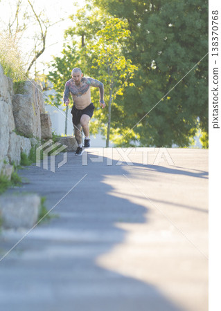 Athletic man running uphill during outdoor training Athletic man running uphill during outdoor training 138370768