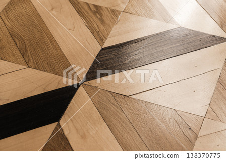 Close-up of parquet wood flooring featuring geometric inlay and warm tones Close-up of parquet wood flooring featuring geometric inlay and warm tones 138370775