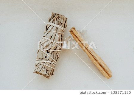 White sage bundle, palo santo stick and clear quartz crystal on light background White sage bundle, palo santo stick and clear quartz crystal on light background 138371130