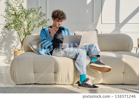 Young man using laptop for video call, online chat conference sitting at home 138371246