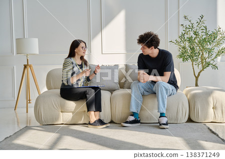 Young male patient in therapy session talking with female psychotherapist Young male patient in therapy session talking with female psychotherapist 138371249