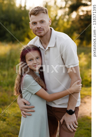 Father Holds Daughter In Field. Loving Father Embraces Daughter In Peaceful Outdoor Setting Father Holds Daughter In Field. Loving Father Embraces Daughter In Peaceful Outdoor Setting 138371395