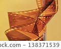 Film strip spiraling creating an abstract shape against warm background 138371539