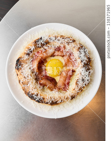 Charming breakfast presentation featuring rustic pizza with egg yolk Charming breakfast presentation featuring rustic pizza with egg yolk 138371965