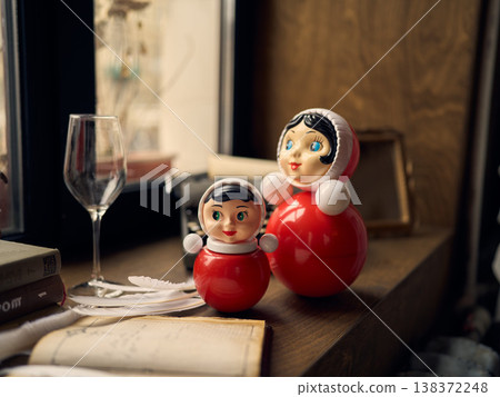 Oldfashioned dolls surrounded by books and warm lighting atmosphere Oldfashioned dolls surrounded by books and warm lighting atmosphere 138372248