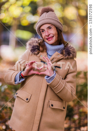 Woman expressing love and hope with heart hands gesture Woman expressing love and hope with heart hands gesture 138372598