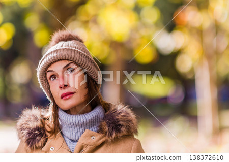 Woman with pensive expression wearing winter clothing outdoors. Eating disorder Woman with pensive expression wearing winter clothing outdoors. Eating disorder 138372610