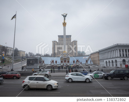 [Ukraine] Cars passing by on the main street in front of Maidan Square in Kyiv, the capital, under a cloudy sky. 138372802