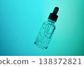 Skincare bottle containing liquid with bubbles on teal gradient background 138372821