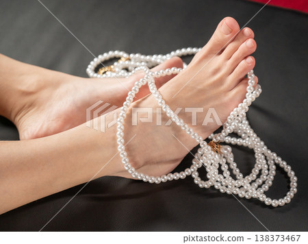 Foot fetish. Bare female feet with pearl beads. Foot fetish. Bare female feet with pearl beads. 138373467