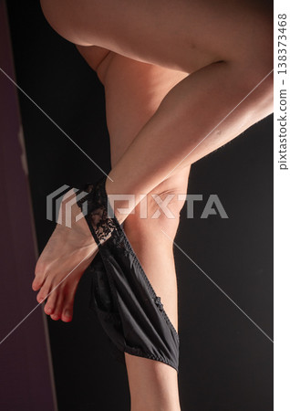 Foot fetish. A woman takes off her black lace panties. 138373468