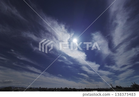 Afternoon sky with cirrus clouds and a halo - ultra-wide angle, sky-focused. Afternoon sky with cirrus clouds and a halo - ultra-wide angle, sky-focused. 138373483