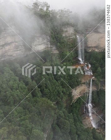 A waterfall on a cliff shrouded in mist – the profound landscape of the Blue Mountains. A waterfall on a cliff shrouded in mist – the profound landscape of the Blue Mountains. 138374682
