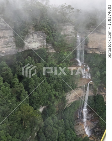 A multi-tiered waterfall shrouded in mist – a deep forest landscape of the Blue Mountains. A multi-tiered waterfall shrouded in mist – a deep forest landscape of the Blue Mountains. 138374683