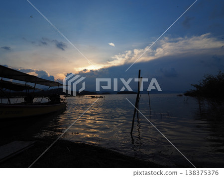 Sunset lake boat reflection silhouette cloud calm sunset lake with small boat reflection silhouette and dramatic cloud sky Sunset lake boat reflection silhouette cloud calm sunset lake with small boat reflection silhouette and dramatic cloud sky 138375376