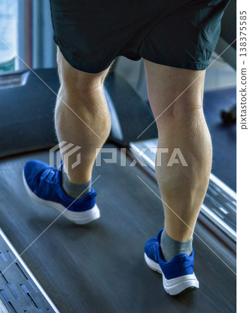 Intense Gym Session With Focused Calf Muscles Moving Rhythmically On Treadmill Intense Gym Session With Focused Calf Muscles Moving Rhythmically On Treadmill 138375585