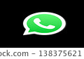 The iconic WhatsApp logo featuring a green speech bubble with a white telephone symbol, set against a stark black background. Represents global communication and instant messaging. 138375621