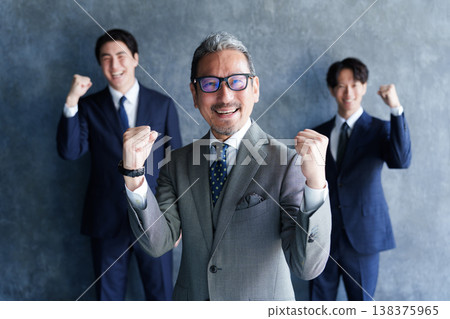 一位商人和他的下屬擺出勝利的姿勢。 一位商人和他的下屬擺出勝利的姿勢。 138375965