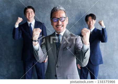 一位商人和他的下屬擺出勝利的姿勢。 一位商人和他的下屬擺出勝利的姿勢。 138375966