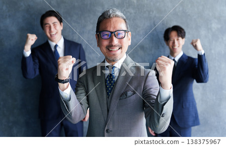 一位商人和他的下屬擺出勝利的姿勢。 一位商人和他的下屬擺出勝利的姿勢。 138375967