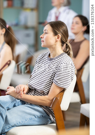 Portrait of pretty young girl student focused listening at lesson in university 138376164
