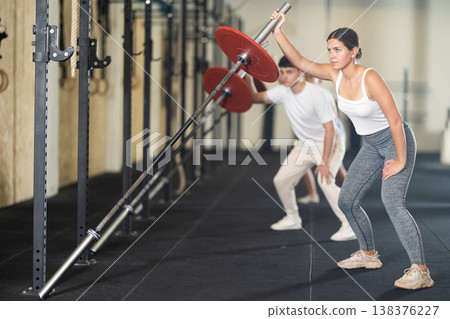 Athletic young woman doing barbell exercises in crossfit gym Athletic young woman doing barbell exercises in crossfit gym 138376227