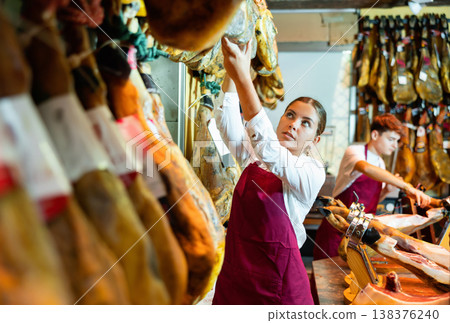 Young salesgirl working in butcher shop specializing in sale of Iberian jamon 138376240