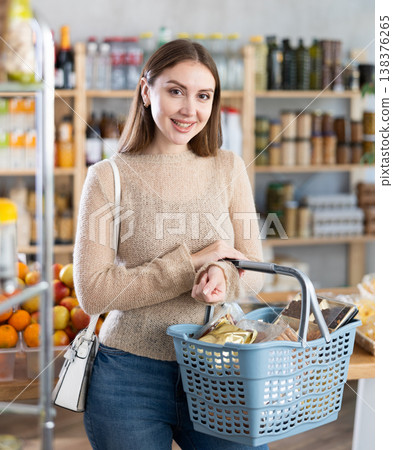 Visiting store, girl is looking at something on shelf of showcase. Visiting store, girl is looking at something on shelf of showcase. 138376265