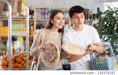 Couple young man and woman choosing pizza Couple young man and woman choosing pizza 138376287