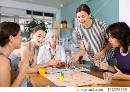 Female colleagues playing board game Female colleagues playing board game 138376389