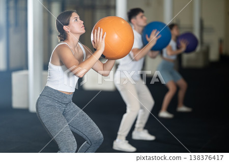 Young woman training with ball in gym Young woman training with ball in gym 138376417