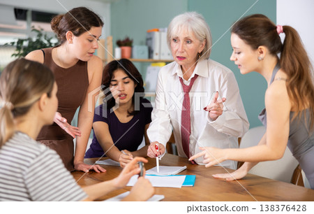 Mature woman standing and leading a group discussion with diverse ladies Mature woman standing and leading a group discussion with diverse ladies 138376428