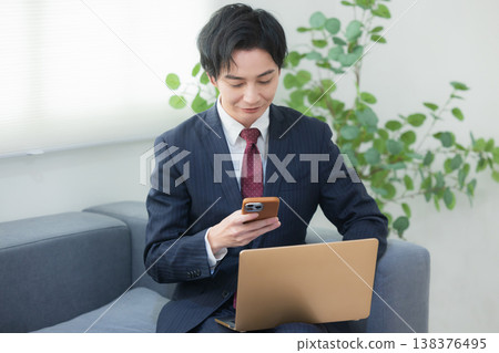 Businessman using laptop in lounge Businessman using laptop in lounge 138376495