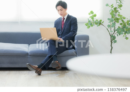 Businessman using laptop in lounge Businessman using laptop in lounge 138376497