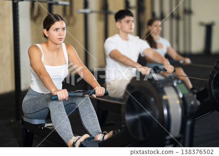 Young woman training her arms on machine 138376502