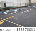 Empty automated coin parking lot in Japan with blue and white locking plate mechanisms. Numbered parking spaces on asphalt surface near a metal fence and industrial building. Professional shot. 138376831