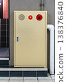 Industrial yellow fire hydrant cabinet with red emergency light and alarm button mounted on a textured wall. Professional safety and fire prevention equipment in a commercial building setting. 138376840
