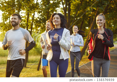 Group of sporty friends people running, jogging outdoors in sunny park, moving together smiling 138376939
