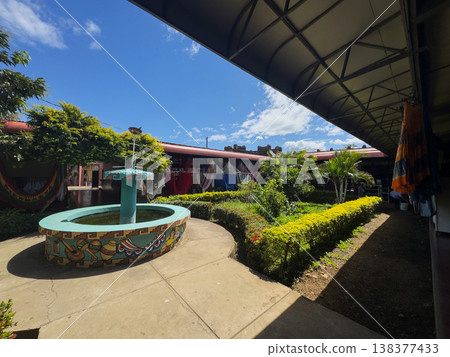 Courtyard with fountain and plants in sunny outdoor setting 138377433